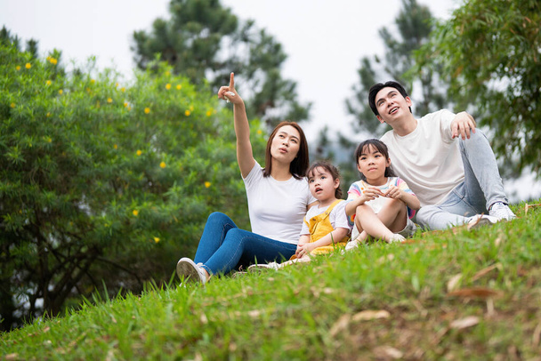 fiatal ázsiai család a parkban - Fotó, kép
