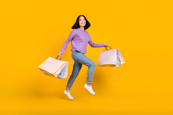 Full length photo of running attractive shopaholic fashionista korean girl shop bags new boutique isolated on yellow color background. - Foto, imagen