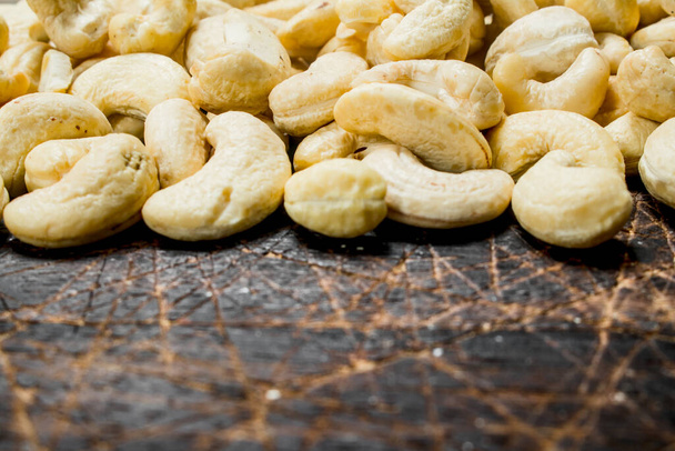 Cashew. On a wooden background. Selective focus - Foto, afbeelding