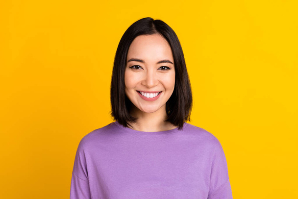 Photo of adorable good mood girl with bob hairdo dressed violet shirt smiling at camera dental ad isolated on yellow color background. - Foto, imagen