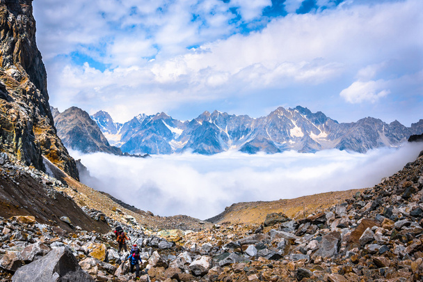 Climbers move in the mountains above the clouds - 写真・画像