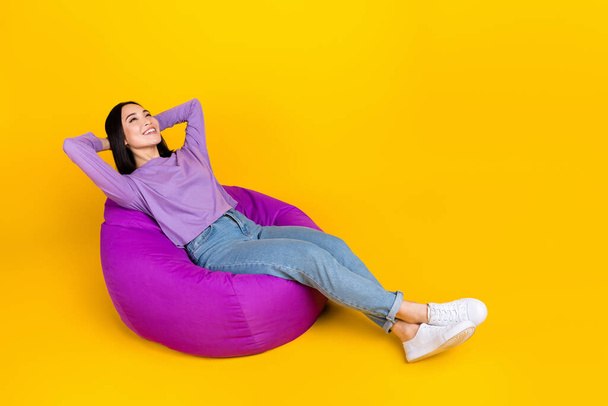 Full size photo of young carefree chinese woman positive lying comfortable pink pouf hands head drowse isolated on yellow color background. - Fotoğraf, Görsel