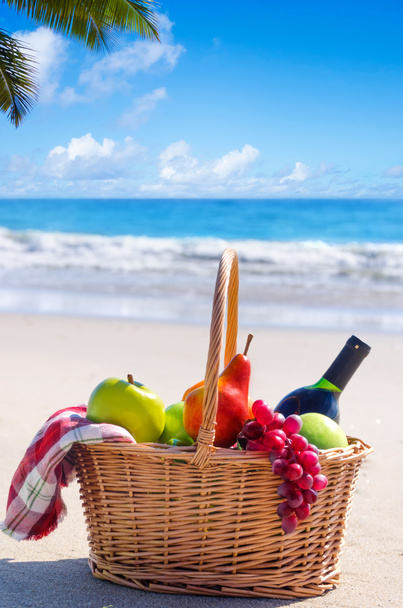 Cesta de picnic con frutas junto al océano
 - Foto, imagen