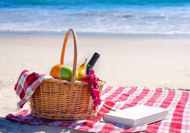 Cesta de picnic con frutas junto al océano
 - Foto, imagen