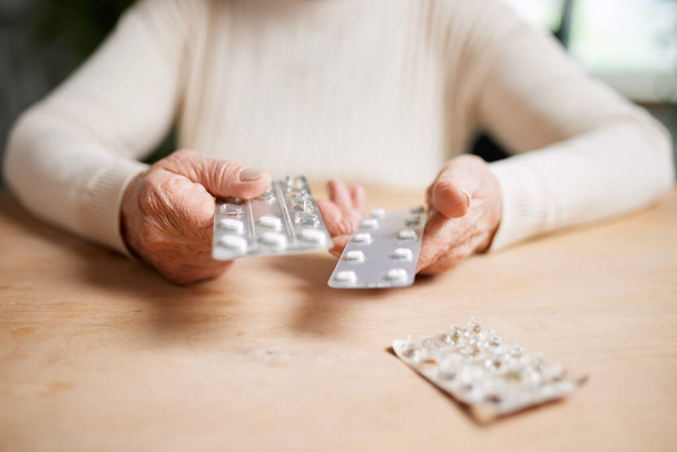 Close-up image of female hands holding pills. Senior woman following her treatment, taking care after health with medical support. Concept of medical care, medicine, illness, health care, profession - Zdjęcie, obraz