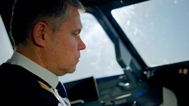 seriózní pilot moderního osobního letadla během letu v kokpitu pracovní pohled z okénka - Záběry, video