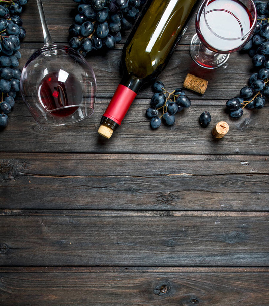 Wine background. Red wine with corkscrew. On a wooden background. - Fotografie, Obrázek