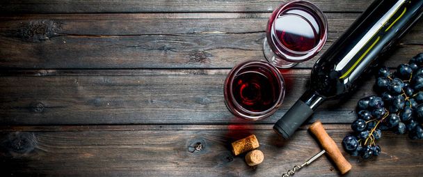 Wine background. Red wine in glasses with grapes. On a wooden background. - Photo, Image