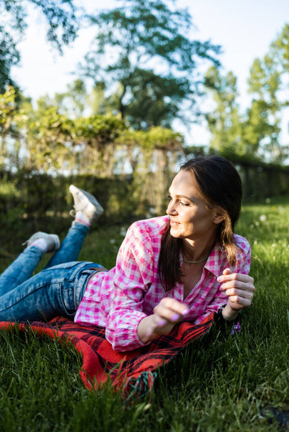 portrait of a beautiful smiling woman relaxing in nature on a warm sunny day - Foto, imagen