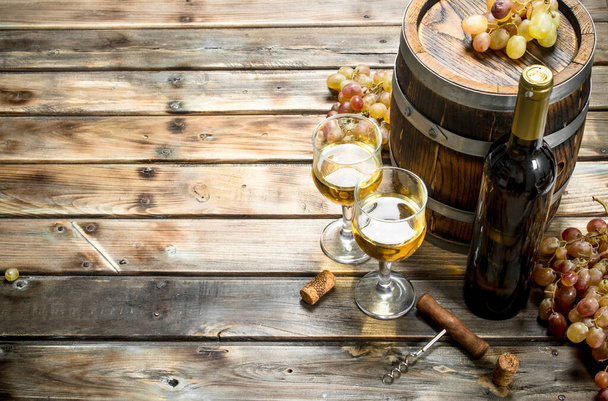 Wine background. White wine in an old barrel. On a wooden background - Zdjęcie, obraz