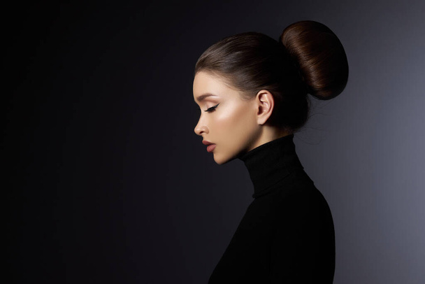 Fashion art studio portrait of beautiful elegant woman in black turtleneck. Hair high beam, perfect profile face. Elegant beauty style. Earrings in the ears - Fotó, kép