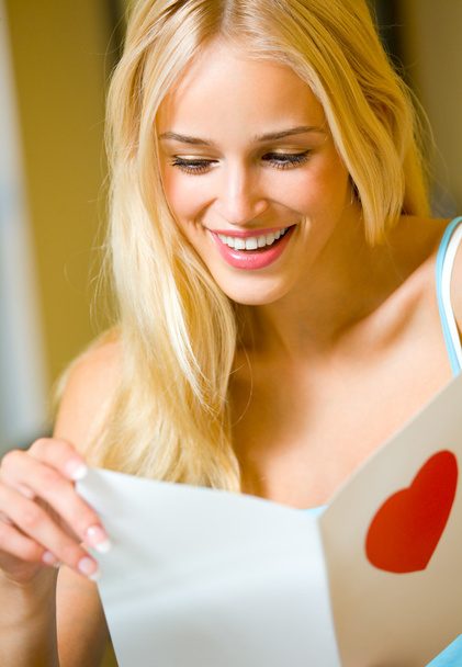 Portrait of young attractive happy woman, reading valentine card - Fotó, kép