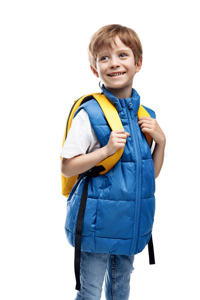 Cheerful little boy wearing yellow backpack looking away on white background. Back to School. Smiling kid - Foto, Imagem