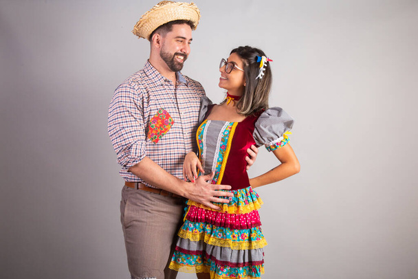 Brazilian couple dressed in festa junina clothes, feast of So Joo embraced - 写真・画像