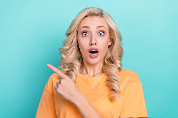 Photo of shiny impressed lady dressed orange t-shirt open mouth showing finger empty space isolated teal color background. - Фото, зображення