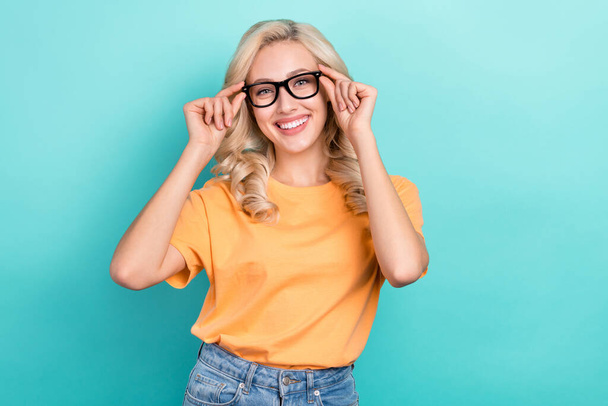 Photo of adorable smart girl wear orange t-shirt arms spectacles smiling empty space isolated turquoise color background. - Φωτογραφία, εικόνα