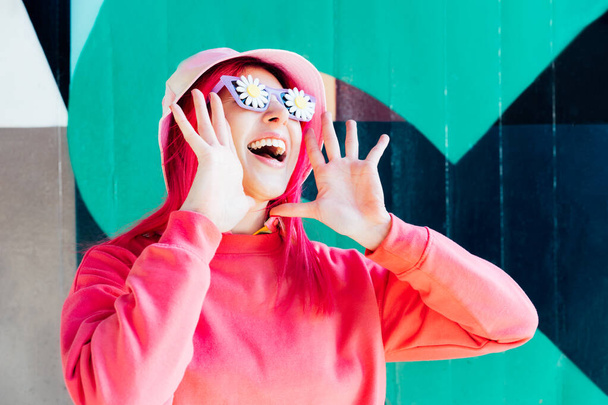 Wow, excited emotional loudly shouting woman in sunglasses with flowers stickers. Playful woman with pink hair,bucket hat and magenta sweatshirt. Vanilla Girl. Kawaii vibe. Candy colors. Flower mood. - Fotó, kép