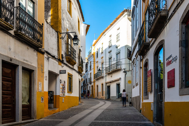 Evora, Portugal - 29 de junio de 2022: Calle peatonal en el casco antiguo con casas típicas encaladas con balcones. Alentejo, Portugal - Foto, Imagen