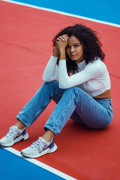 beautiful woman with dark and curly skin in a photo session on the court - Valokuva, kuva
