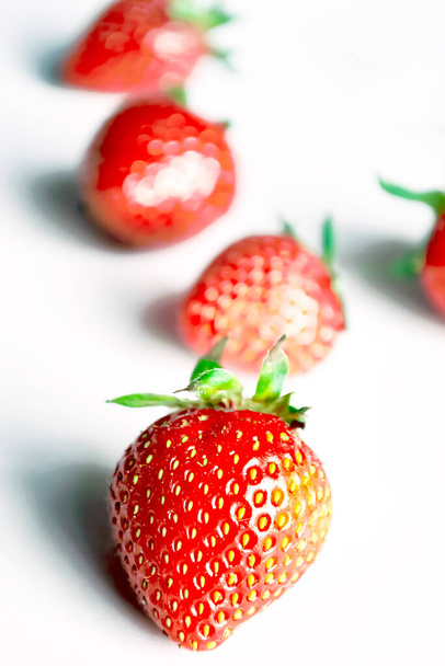 Φράουλες με μέντα σε λευκό φόντο. Φωτεινό φόντο με κόκκινες φράουλες και πράσινη μέντα. Συστατικά για καλοκαιρινά δροσιστικά πιάτα. - Φωτογραφία, εικόνα