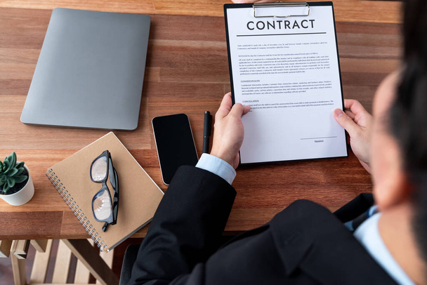 Businessman review agreement document before signing contract. Reading carefully to ensure trade deal align with business goals. Professionalism for business decision making concept. Jubilant - Photo, Image
