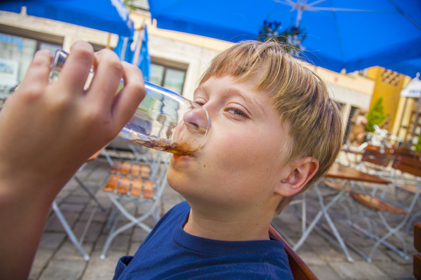 chlapec se těší, pití v zahradní restauraci - Fotografie, Obrázek