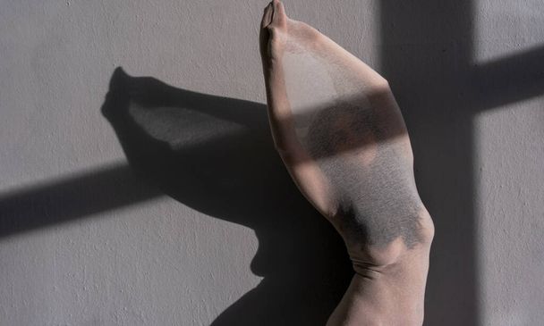 giovane donna nuda in bianco vestito di cotone trasparente calza come una scultura vivente moderna tra luce solare e ombra, spostando il corpo a lato, copiare lo spazio - Foto, immagini