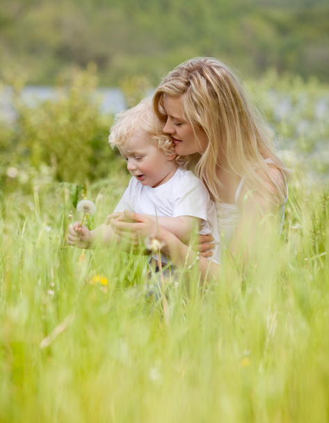 Mother and Son with Dandelion in Meadow - Фото, изображение