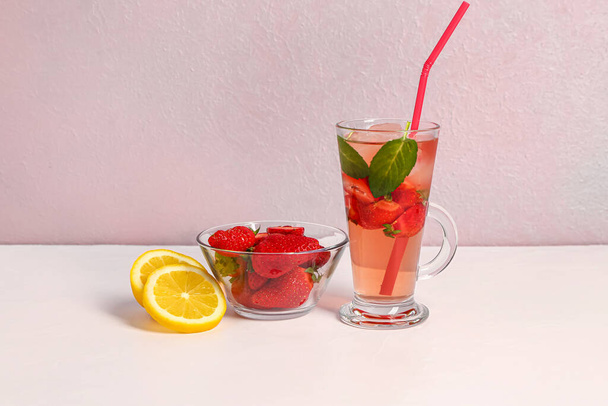 Glass of juice and bowl with strawberry on white table - Zdjęcie, obraz
