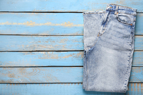 Стильные джинсы в джинсах на синем деревянном фоне - Фото, изображение