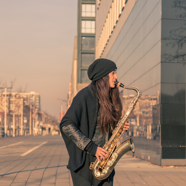 Beautiful young woman playing tenor saxophone - Fotó, kép