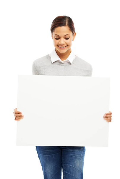 A tua mensagem interessa-a. Retrato de estúdio de uma jovem atraente segurando um cartaz em branco isolado em branco - Foto, Imagem