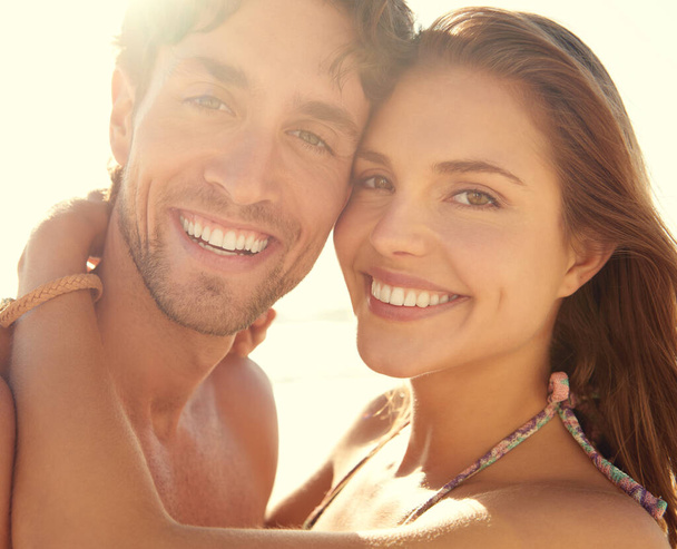 Целующиеся солнцем любовники. Крупный план портрета ласковой молодой пары, наслаждающейся отдыхом на пляже - Фото, изображение