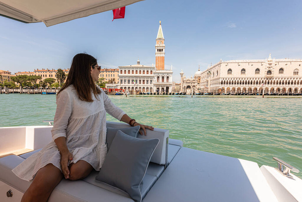 コーカサスの素晴らしい女性は豪華なヨットからヴェネツィアに見えます,イタリア - 写真・画像