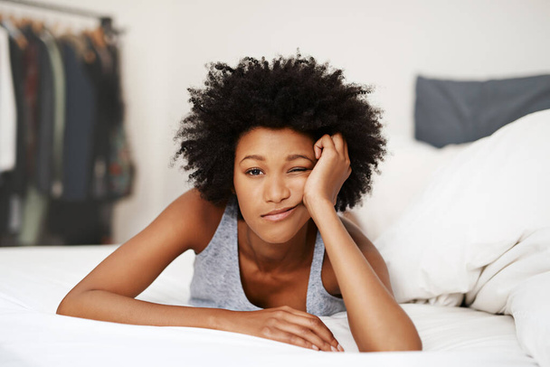 Portrait, bed and black woman waking up, bored and upset with fatigue, lazy and unhappy at home. Face, female person and girl in the bedroom, frustrated and tired with a headache, depressed and sad. - Photo, image