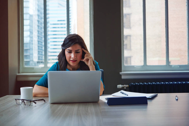 BYOD brengt haar dichter bij zakelijke kansen. een zakenvrouw die een laptop gebruikt in een kantoor - Foto, afbeelding