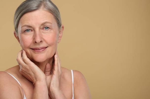Portrait of senior woman with aging skin on beige background, space for text. Rejuvenation treatment - Foto, Imagen