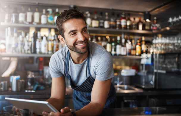 Sorridi, pensa e un barista con un tablet in un caffè per ordini e comunicazioni online. Felice, idee e un gestore di pub maschile o barista con tecnologia per un'app, connessione e ordinazione di magazzino. - Foto, immagini