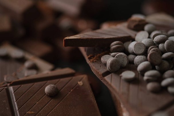 Крупный план кусочков шоколада с шоколадной крошкой. - Фото, изображение