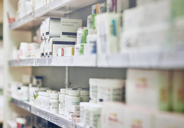 Closeup, pharmacy and medicine with healthcare, pills and shelf with boxes, bottles and treatment. Zoom, medication and package with container, retail and store with pharmaceutical, items or products. - Photo, Image