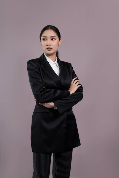 Confident young businesswoman stands on isolated background, posing in formal black suit. Office lady or manager with smart and professional appearance. Enthusiastic - Foto, afbeelding