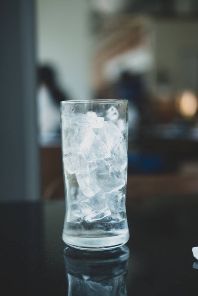 テーブルの上に氷のキューブでガラスを閉じます - 写真・画像