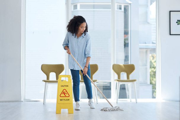 Cleaning, floor and woman mopping with caution in building of maintenance, hygiene and dirt. Mop, janitor service and cleaner with warning sign, notice and safety information on ground tiles at home. - Fotoğraf, Görsel