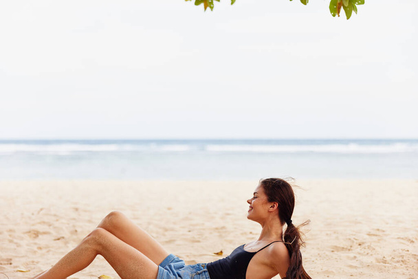 γυναίκα μόδα νεαρός άνδρας σώμα ήλιος παραλία χαλαρώστε ελκυστική ομορφιά φύση διακοπές θάλασσα χαμόγελο ελευθερία τρόπος ζωής συνεδρίαση διακοπές άμμο ταξίδια ξέγνοιαστες - Φωτογραφία, εικόνα