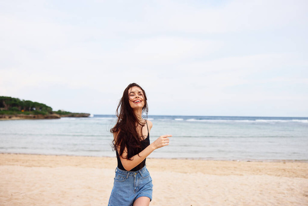 Космическая женщина пляж женский молодой экземпляр расслабиться улыбка волосы бегущий океан летом тело положительный закат образ жизни весело природу берега путешествия улыбаясь - Фото, изображение