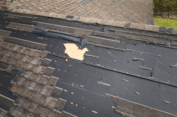 Damaged house roof with missing shingles after hurricane Ian in Florida. Consequences of natural disaster. - Photo, Image