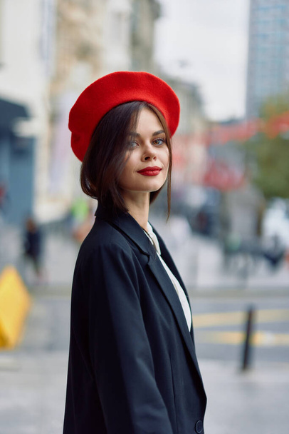 Muoti nainen hymyilee keväällä kävely kaupungin tyylikäs vaatteita punaiset huulet ja punainen baskeri, matkailu, elokuvamainen väri, retro vintage tyyli, kaupunkien muoti elämäntapa. Laadukas kuva - Valokuva, kuva