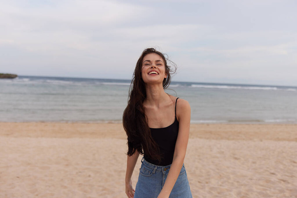 γυναίκα ευτυχισμένη χαμογελώντας όμορφες διακοπές ηλιοβασίλεμα ελευθερία καλοκαίρι μακριά θάλασσα θηλυκό τρέχει ταξίδι πρόσωπο παραλία φύση ανατολή ζωή νέος χαμόγελο θάλασσα μαλλιά - Φωτογραφία, εικόνα