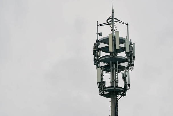 Makro bázisállomás. 4G LTE Advanced és 5G cellás telekommunikációs torony. 5G rádió hálózati távközlési berendezések rádiómodulok és intelligens antennák szerelt fémre ellen cloulds ég háttér. - Fotó, kép