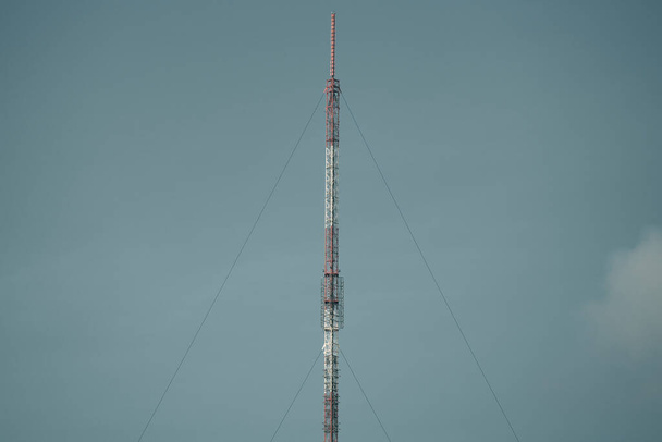 A cell phone tower with a dark sky behind it. - Zdjęcie, obraz